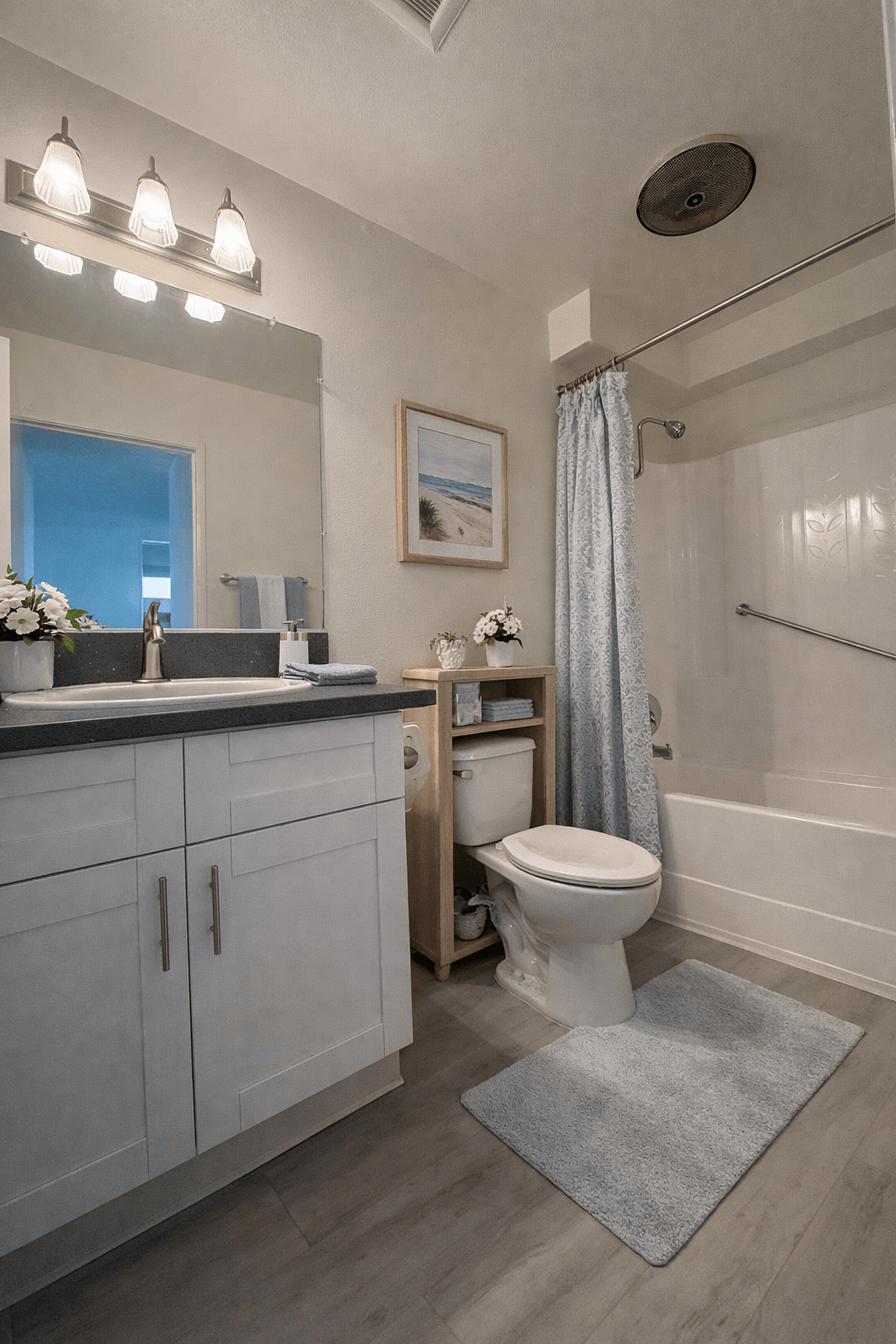 A bathroom with a toilet, sink, and shower.